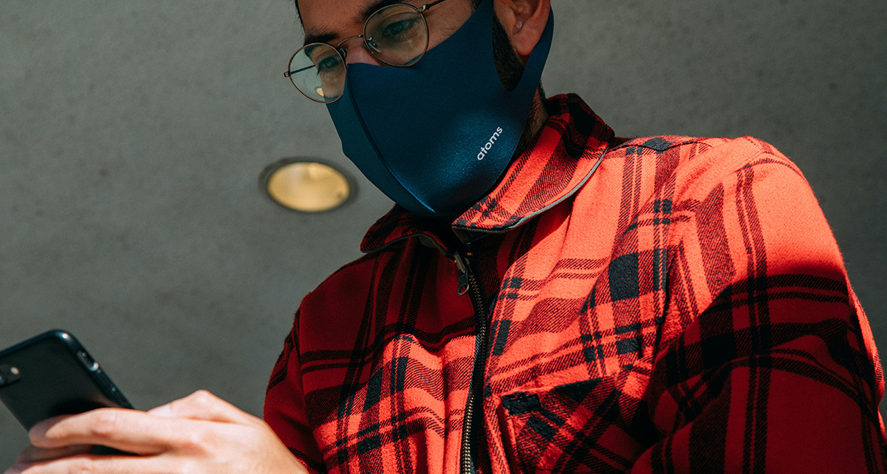 person in mask using smart phone and facial recognition